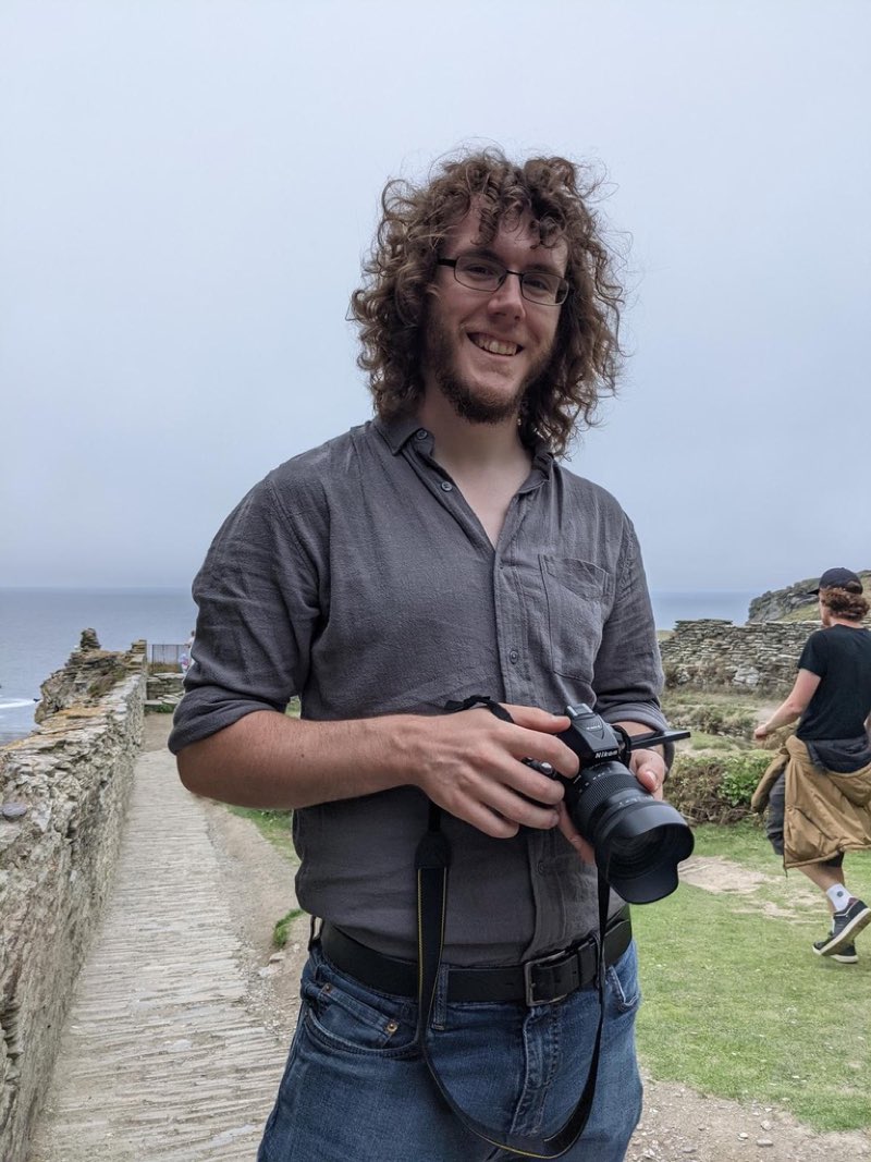 Chad, holding a camera on a stone coastal path
